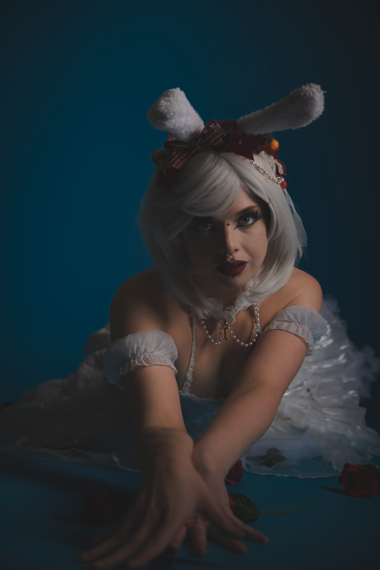 Artistic portrait series featuring delicate white dress and floral details in dramatic lighting.