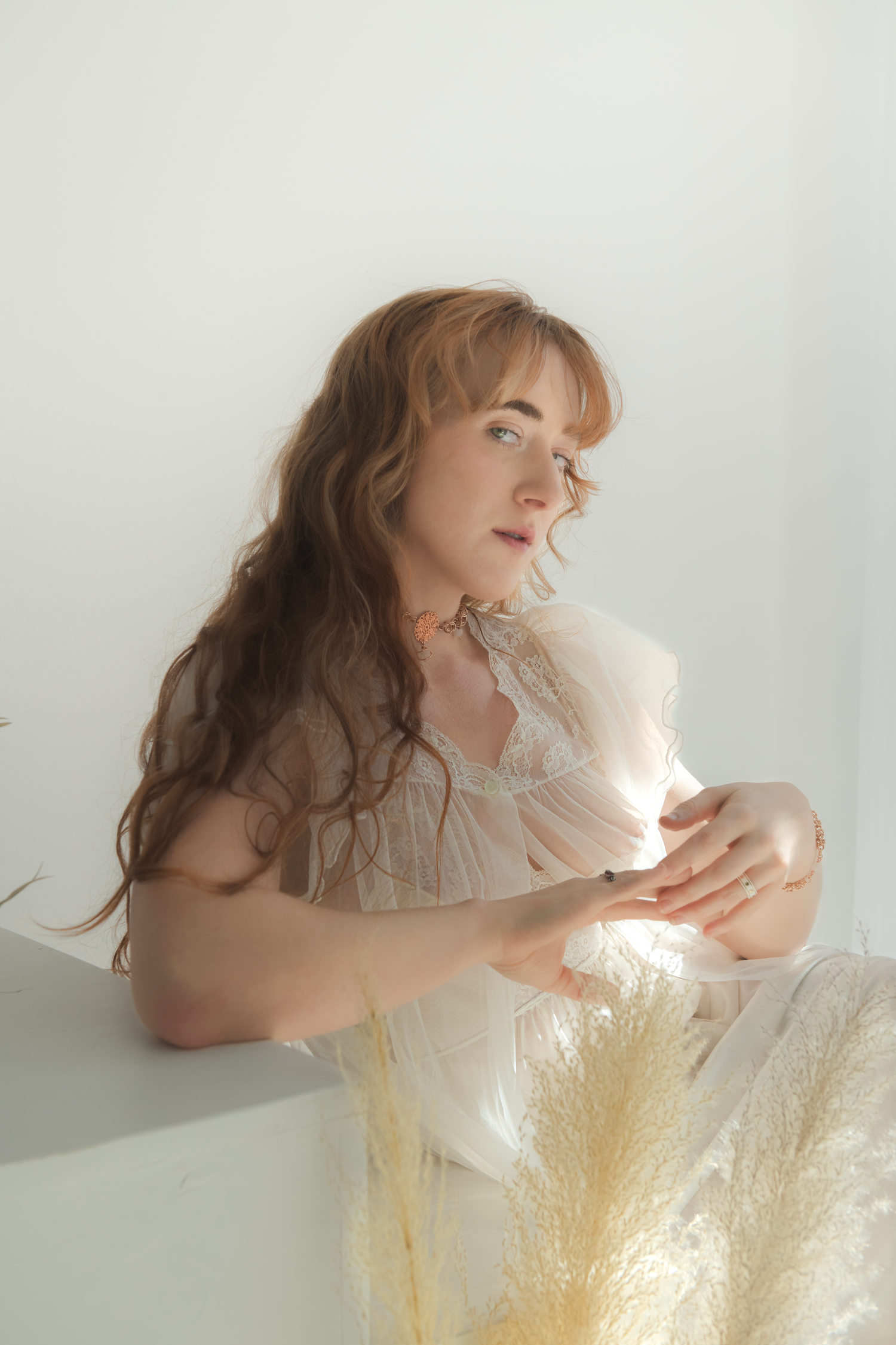 Artistic portrait series showing ethereal poses with flowing golden fabric and soft natural lighting.
