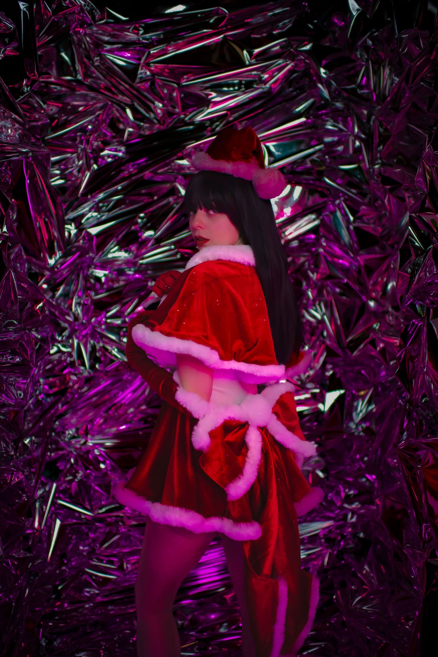 Silhouette in red holiday costume shown against sparkly purple metallic background.