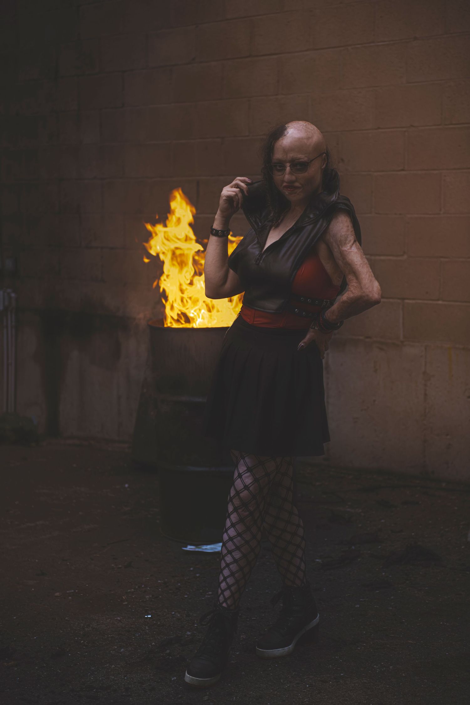A sequence of cinematic shots showing someone performing fire breathing tricks against a dark wall at night.