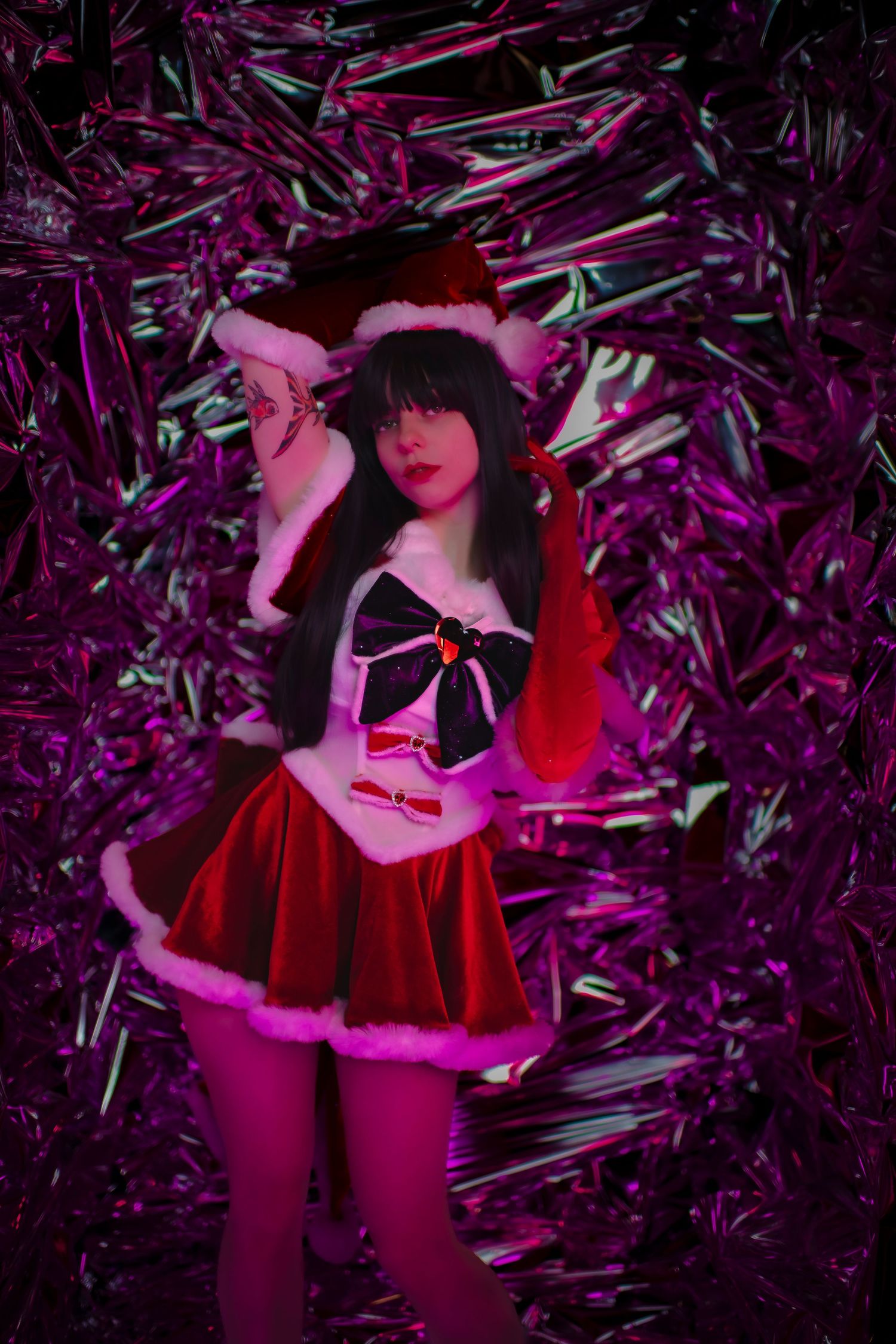 Figure in red performs against a metallic purple backdrop with dramatic magenta lighting.