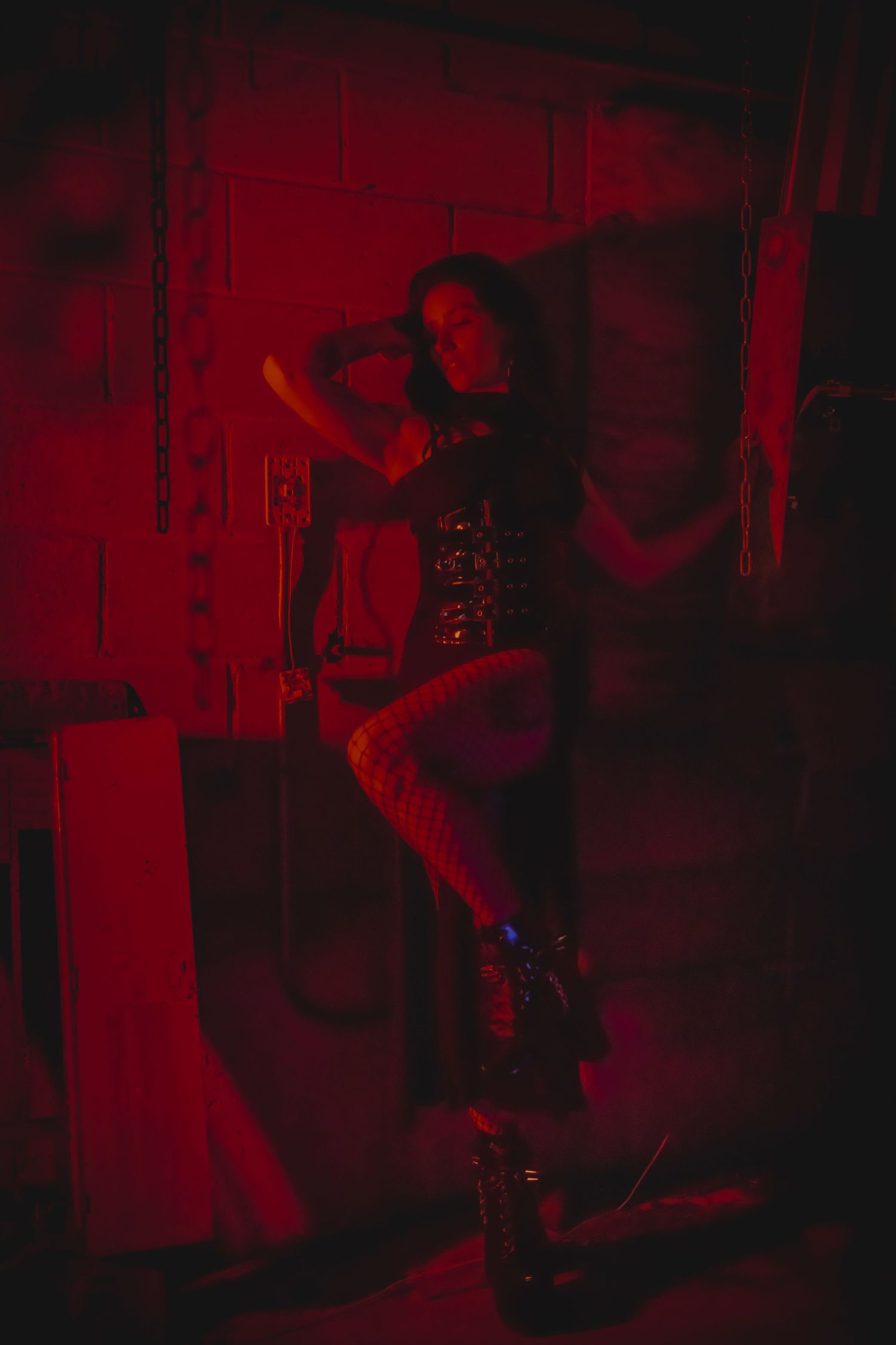 Atmospheric red-lit photo sequence showing a darkened figure playing guitar on stage during a performance.