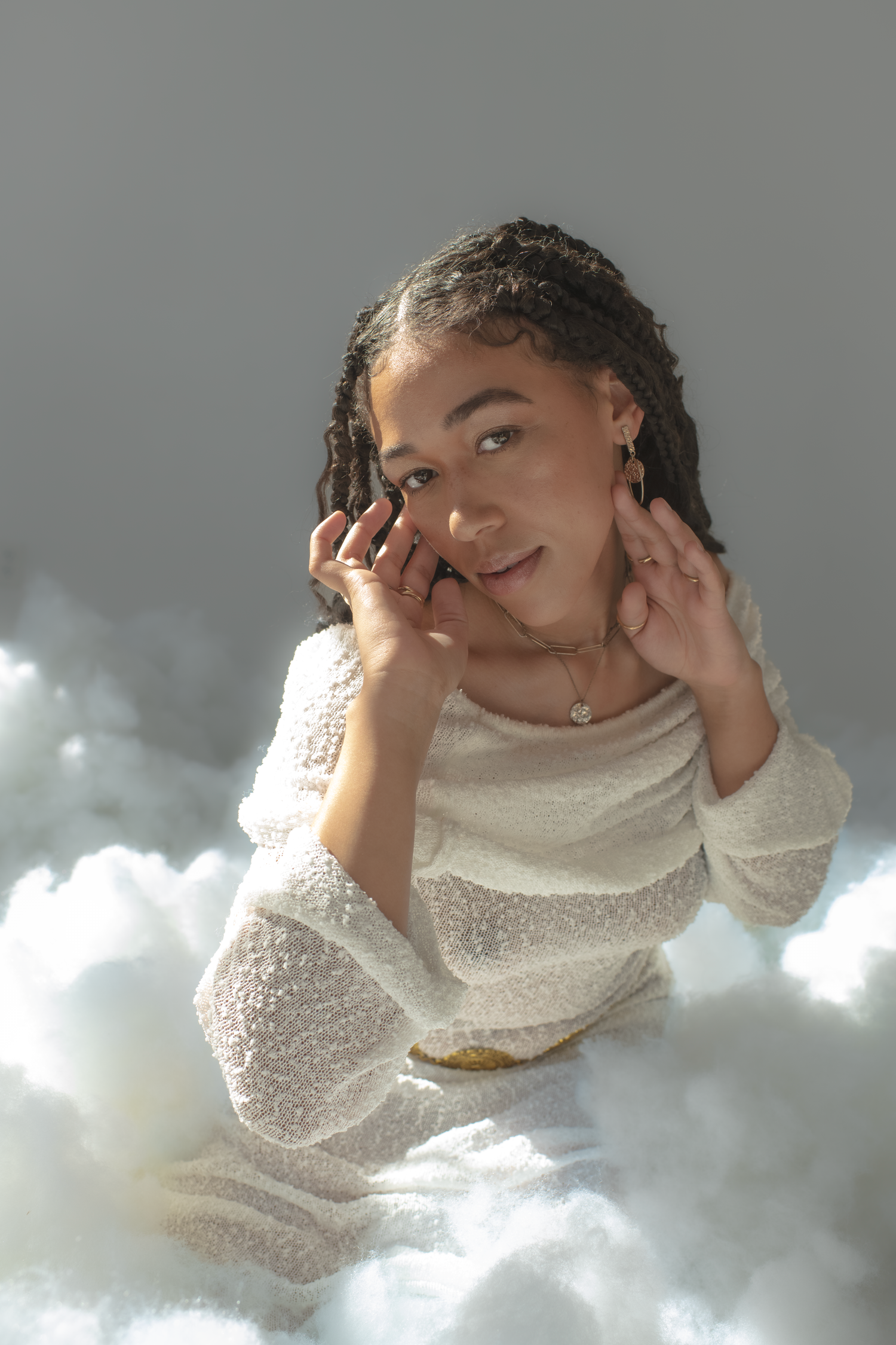 Artistic portraits with soft lighting against a cloudy backdrop creating a dreamy, ethereal mood.