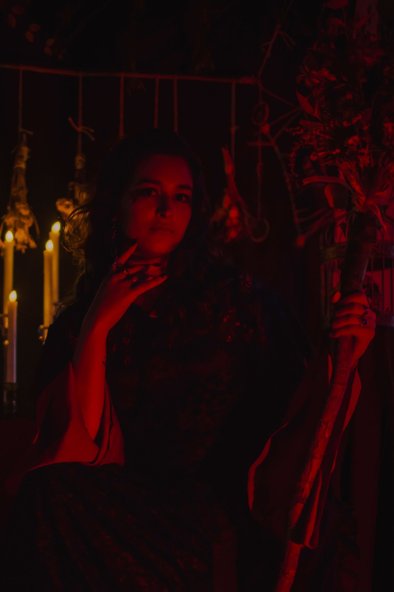 Dark red-tinted photographs arranged in sequence showing a person making dramatic gestures in low lighting conditions.