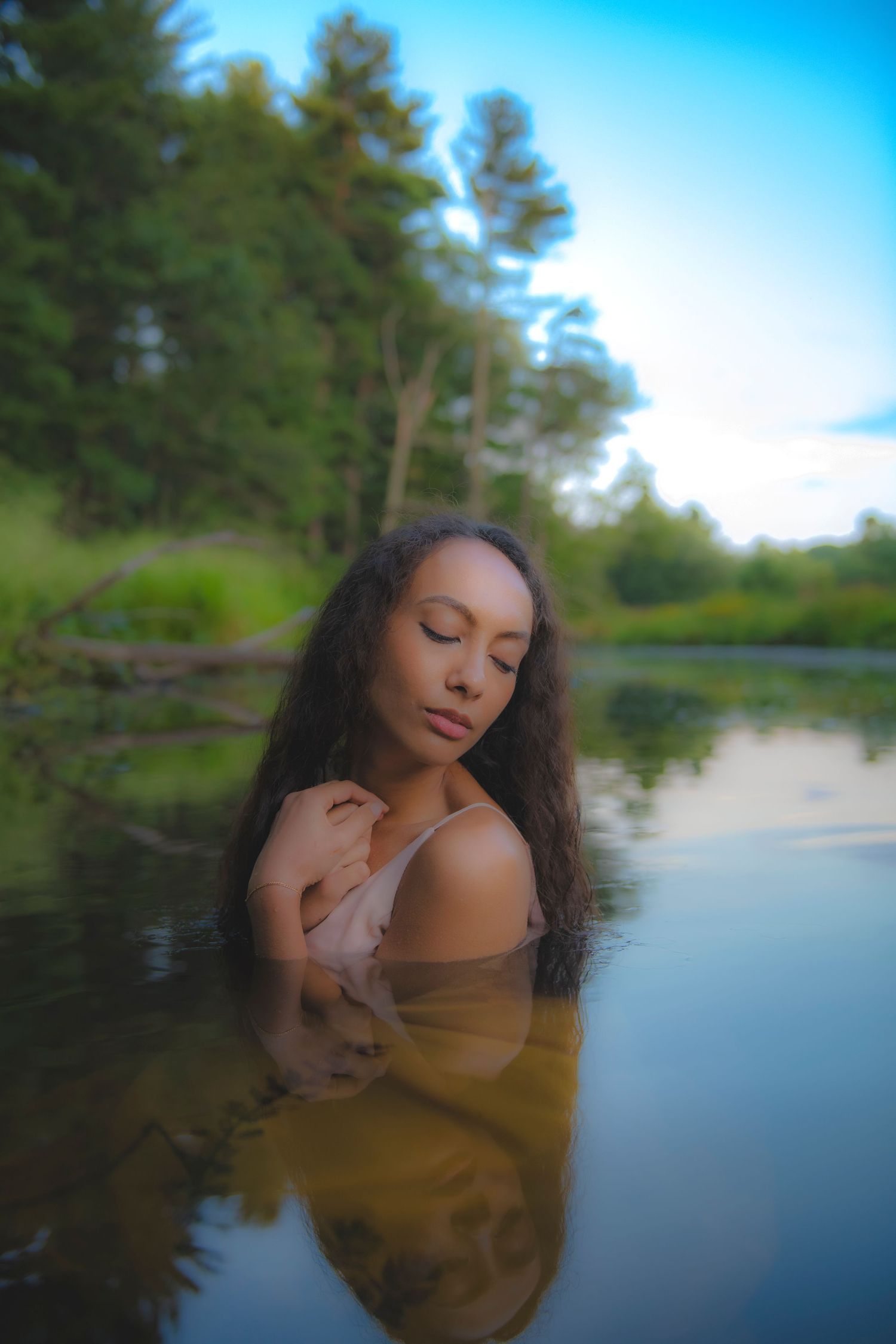 Artistic portrait in a serene lake setting with pine trees and reflective water at dusk.