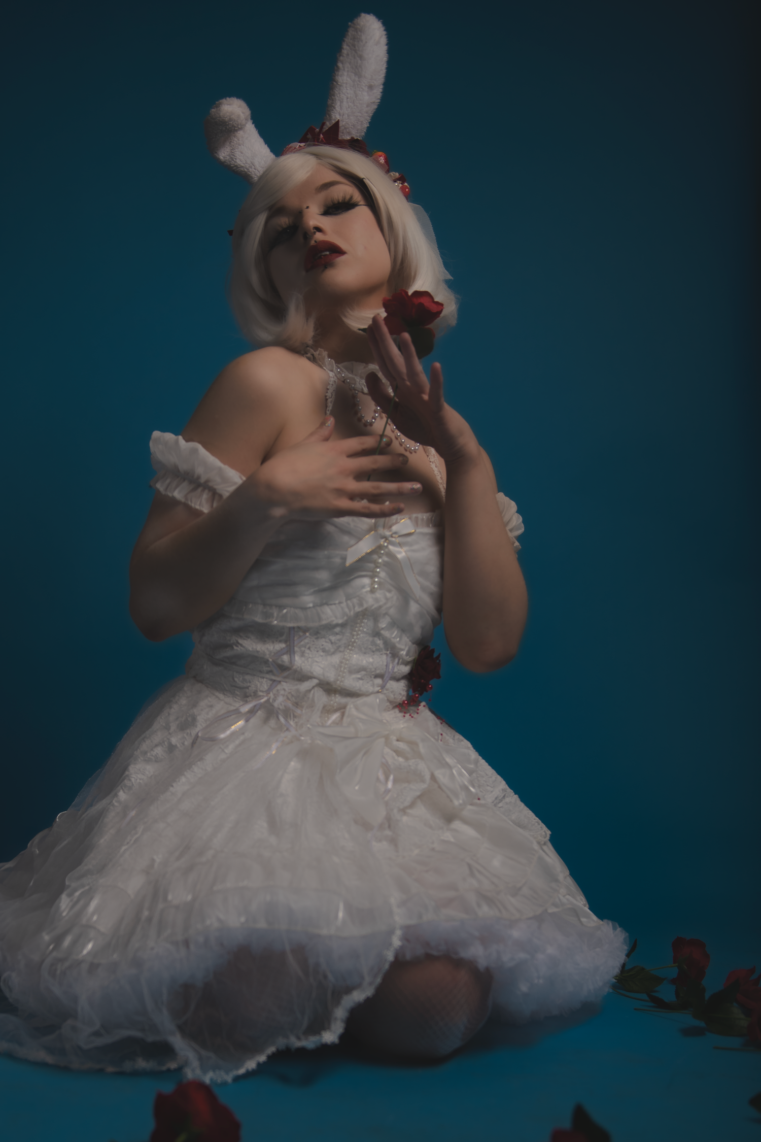 An ethereal portrait in white featuring a model in a bunny-inspired costume with delicate lace details.