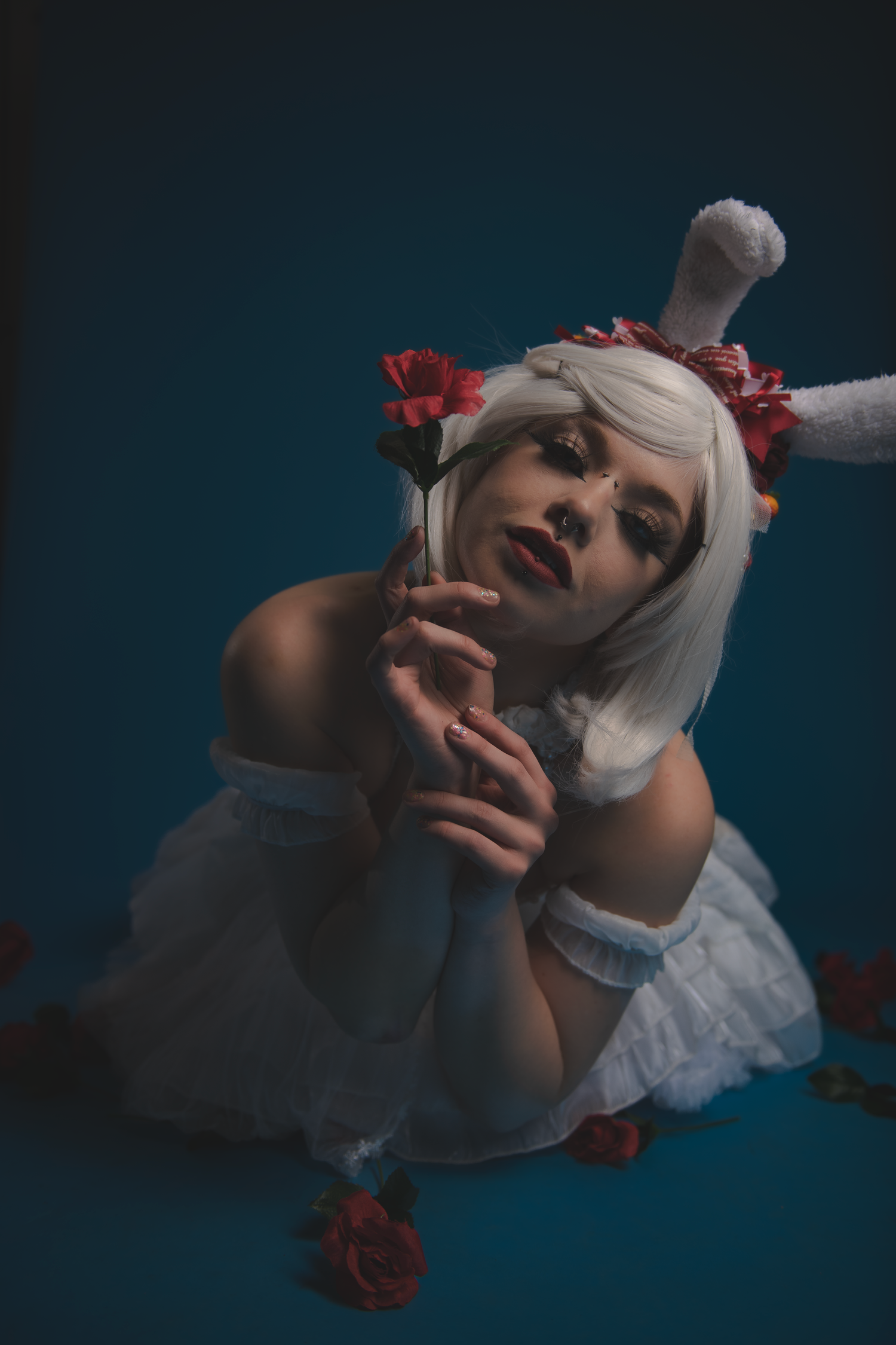 Artistic dark portrait series with red roses showing dramatic poses against deep blue background.