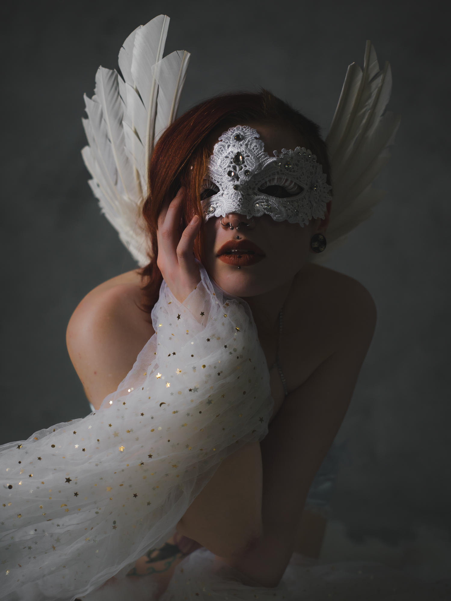A series of ethereal photos showing white tulle fabric and feathers against a dark background creating a dreamy atmosphere.