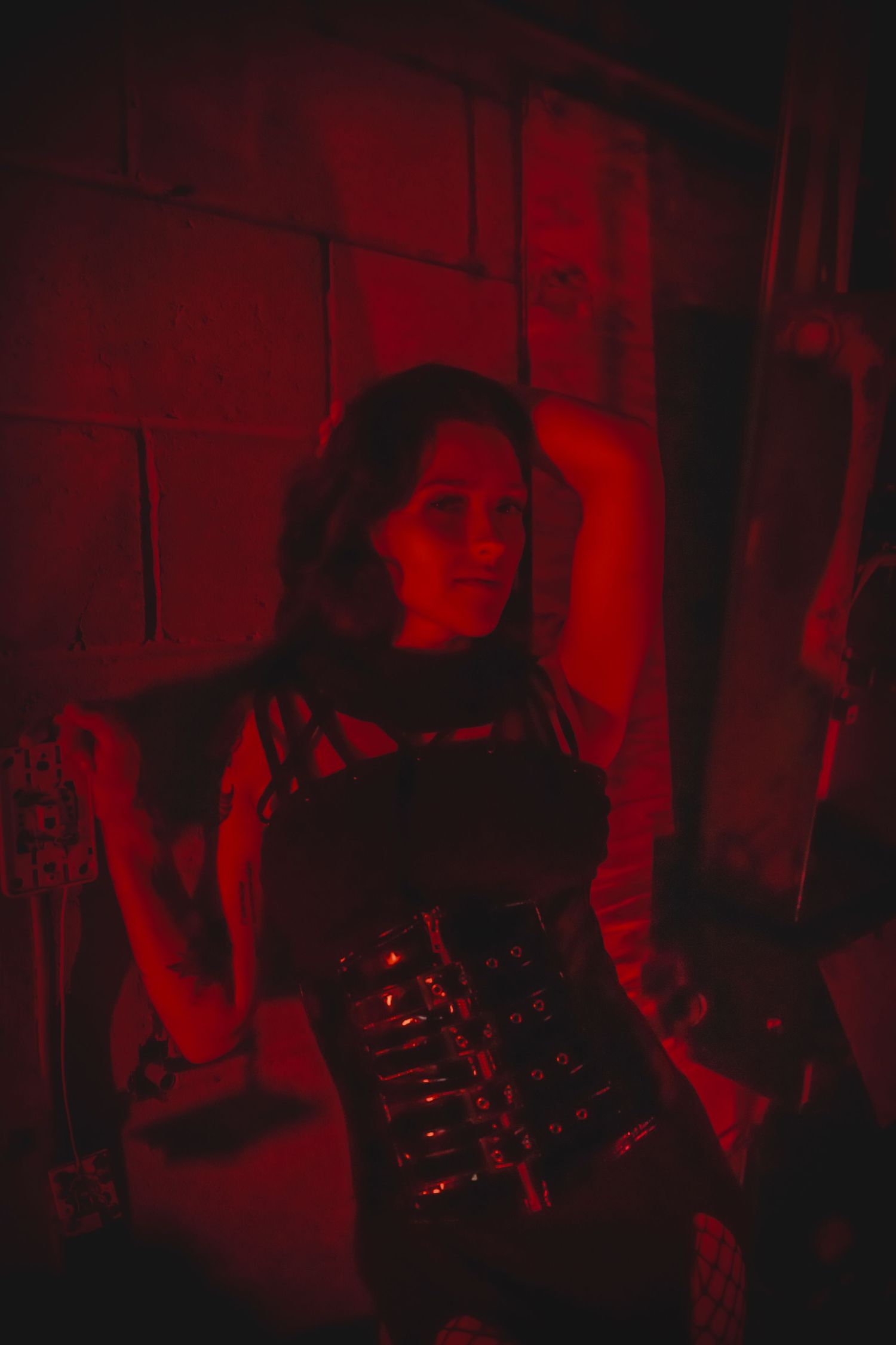 Moody series of red-tinted performance photos showing live musicians during a concert under dark, atmospheric lighting.