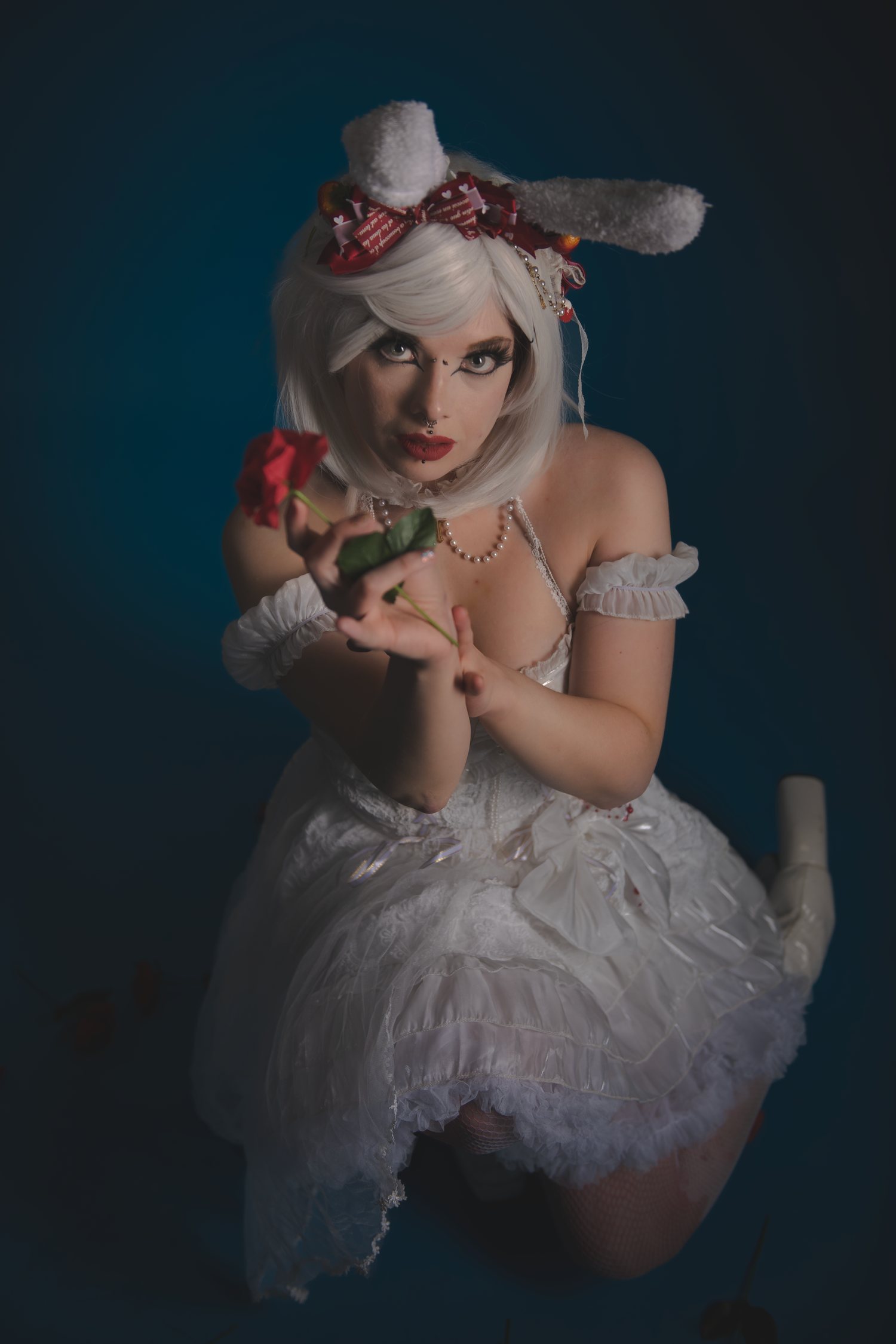 Dramatic image of figure in white tulle costume with floral accents against blue background.