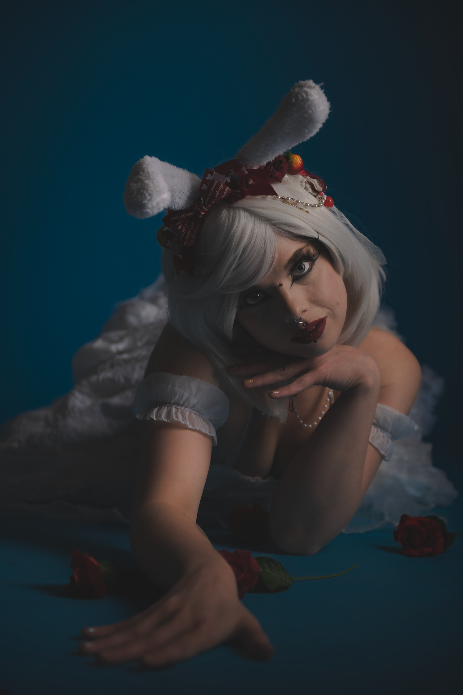 Moody fashion photography with white costume against dark background.