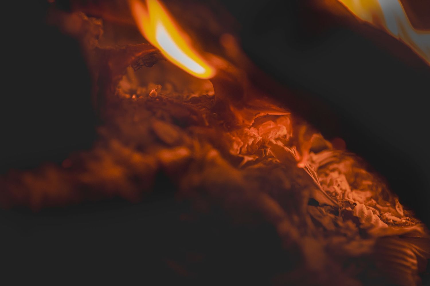 Close-up macro images of orange flames with intricate patterns and swirling textures against a black background.