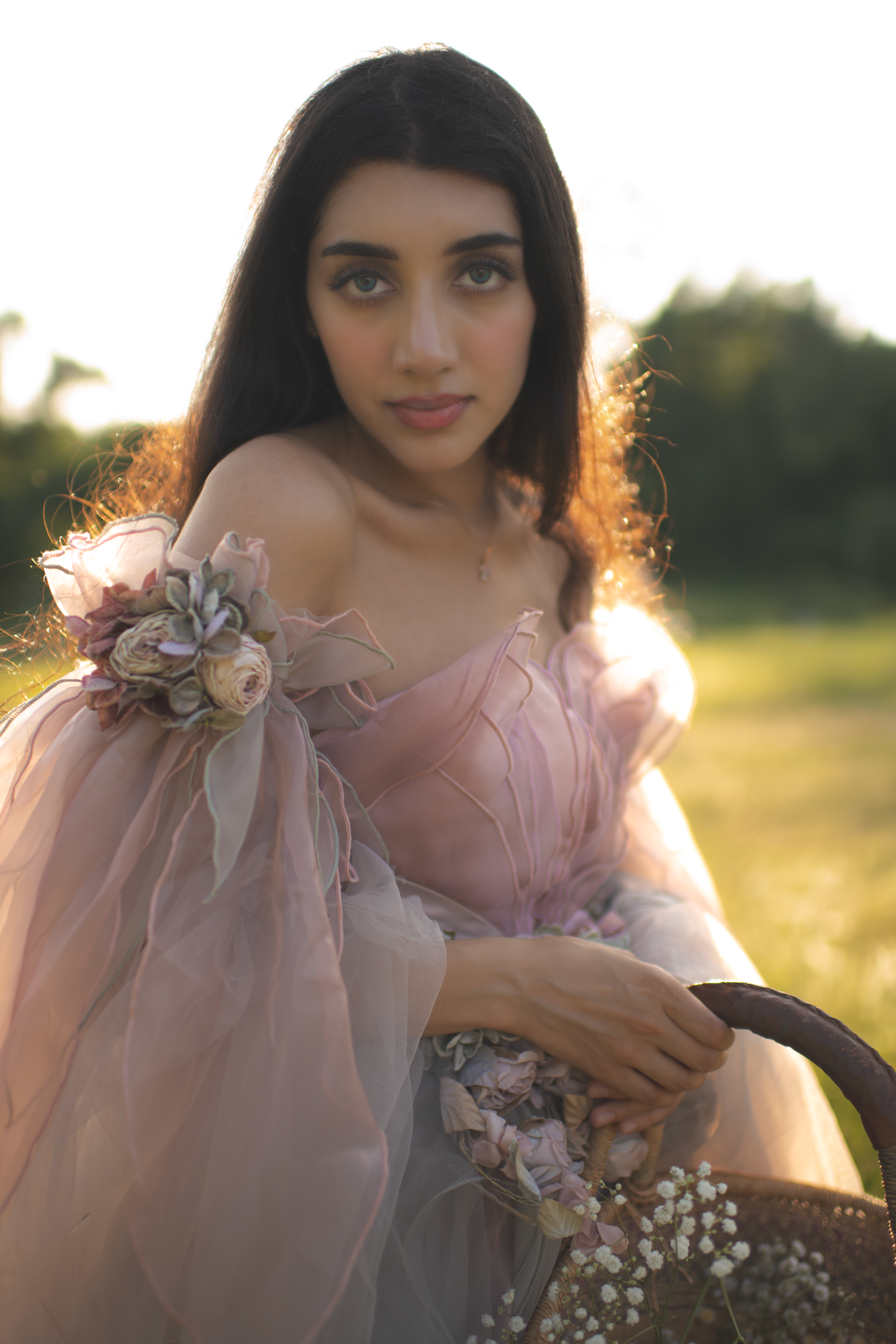 Ethereal portrait series in a pink dress with floral details captured during golden hour in a dreamy outdoor setting.