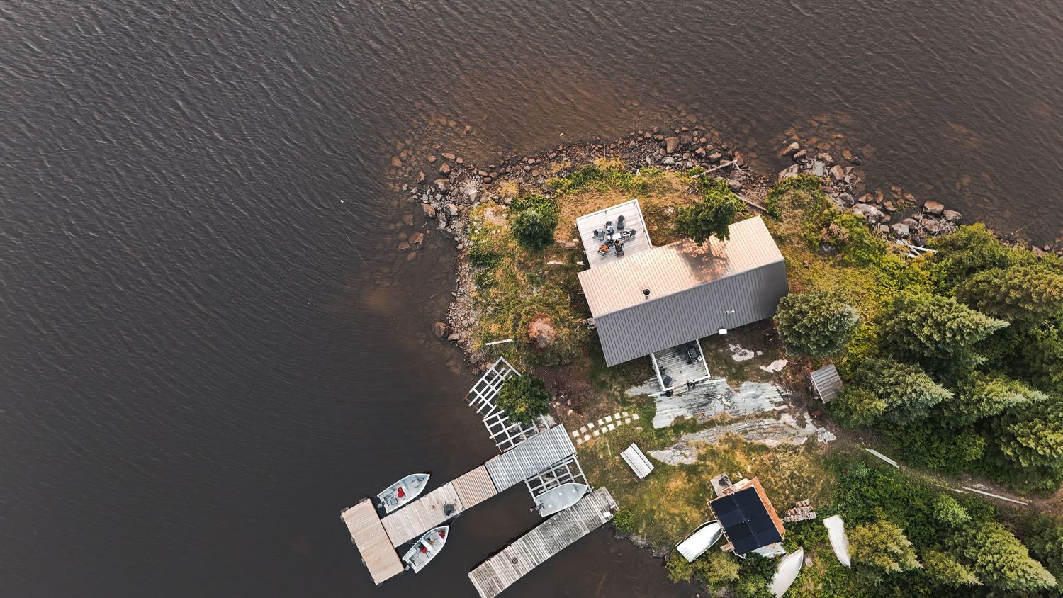 Aerial view of a tranquil lake with forested islands and scattered waterfront properties.