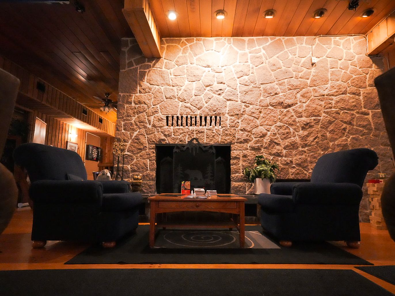 Cozy lodge interior with stone walls, ambient lighting, and comfortable seating areas.