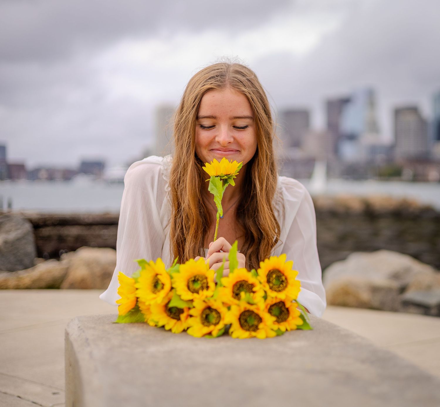 A series of creative images showing someone posing with vibrant sunflowers against a beach backdrop.