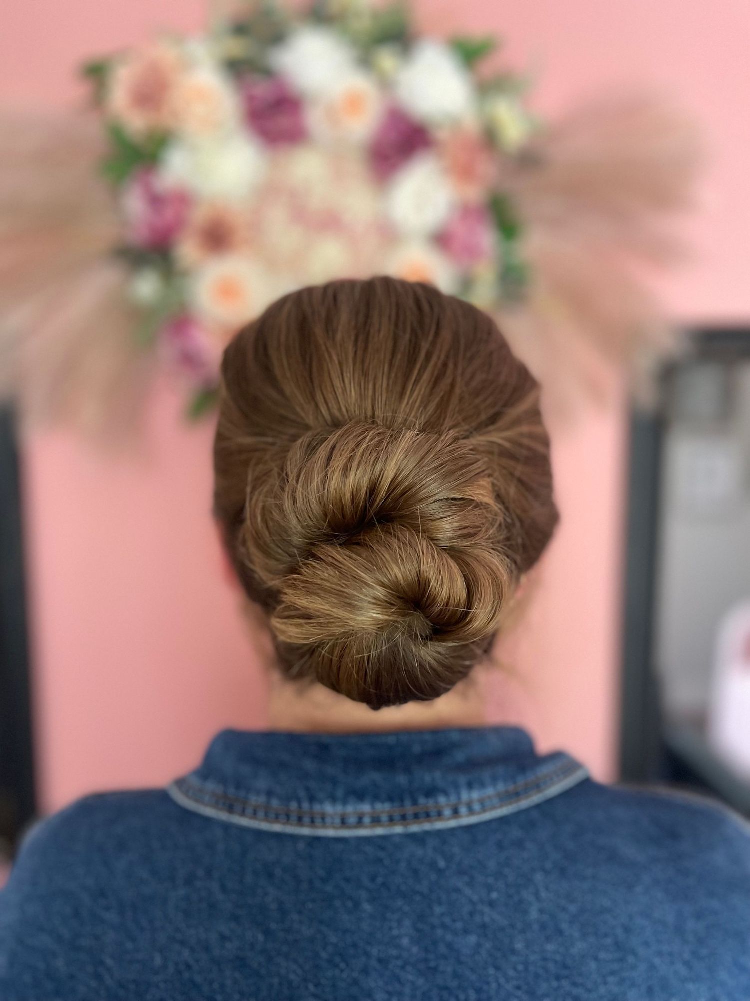 Very thick long hair twisted back into a mid bun keeping a neat texture perfect for a bridal style