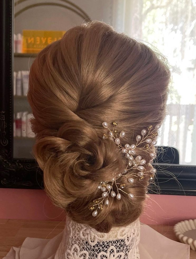 Vintage neat low bun high shine with a hair flower detail finished with a pearl accessory