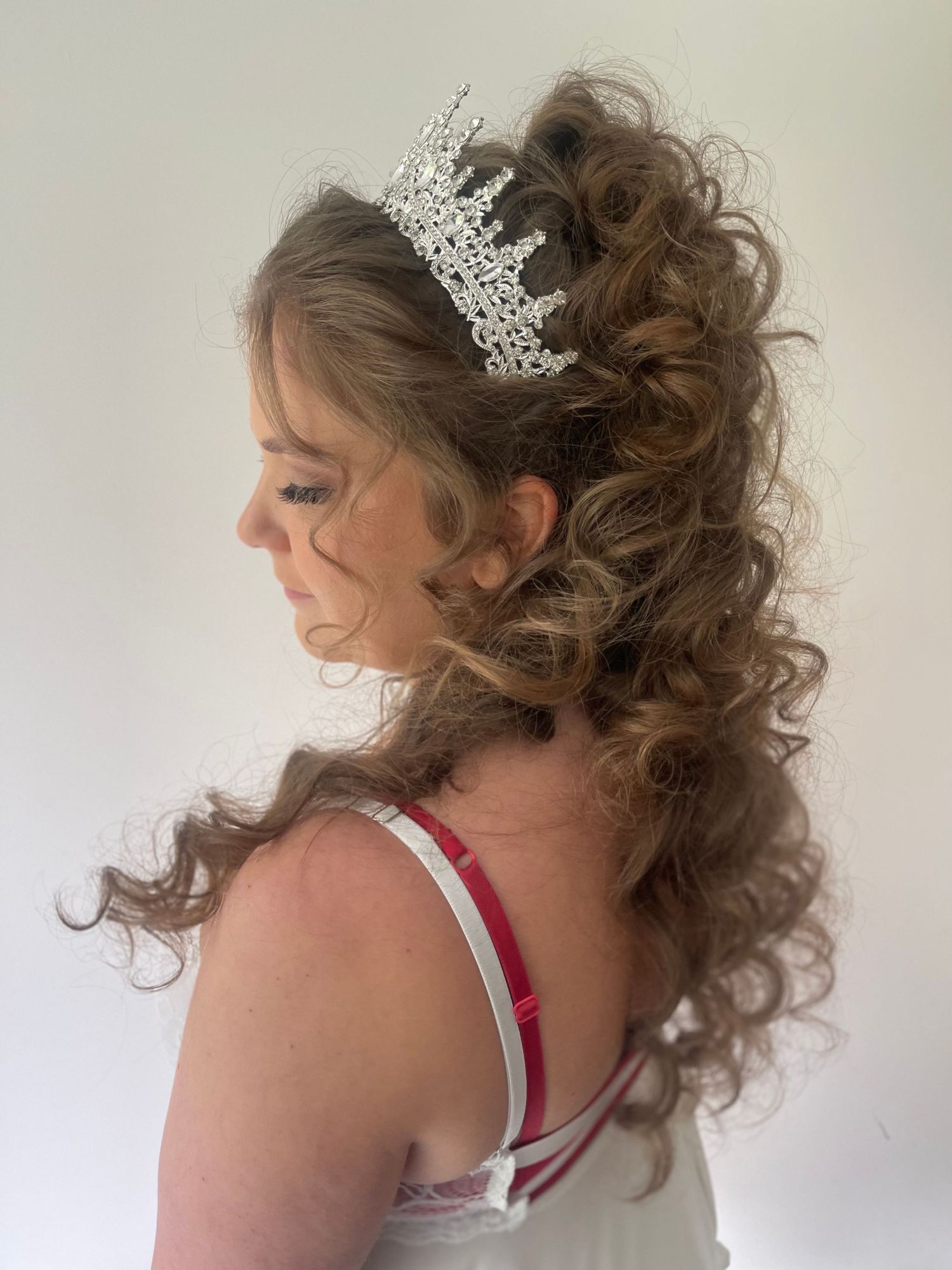 Long fine hair but curled tightly for a princess textured half up half down style finished off with a beautiful shiny tiara