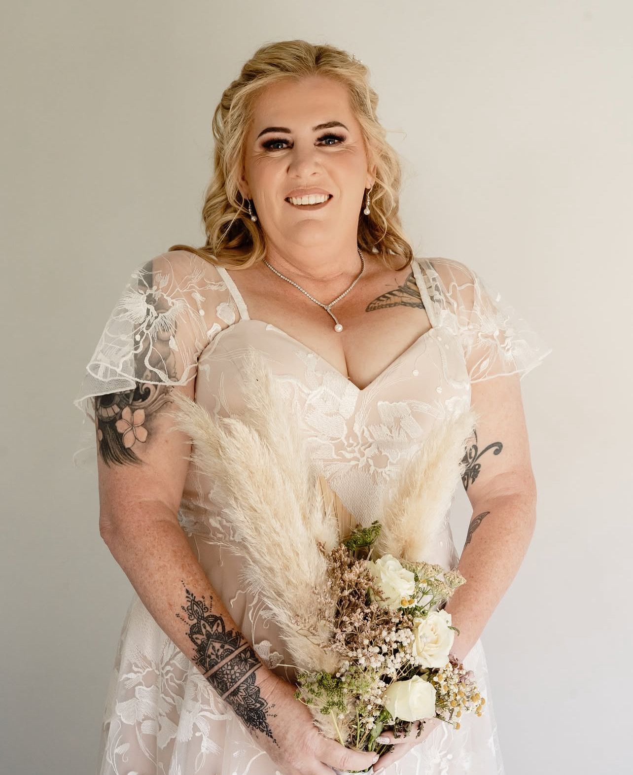 Portraits of a bride with thick long blonde hair with extensions for length tightly curled for a textured half up half down bridal style