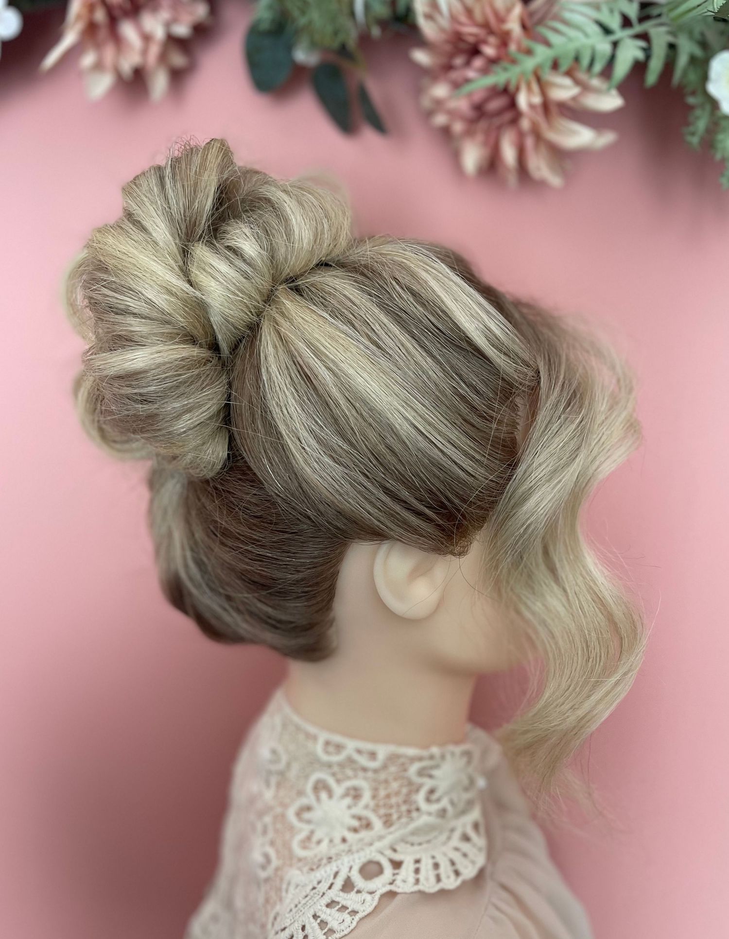 High French twist in blonde long hair curled into a textured top and a thick fringe