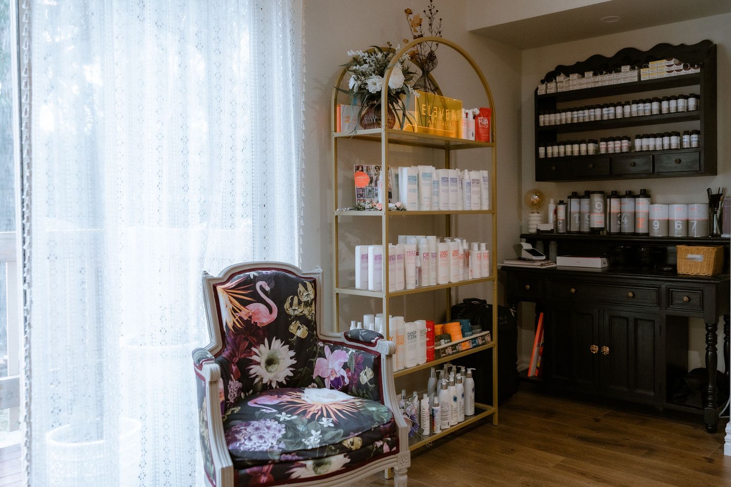 Vintage patterned chair in window of salon setting with hair salon products