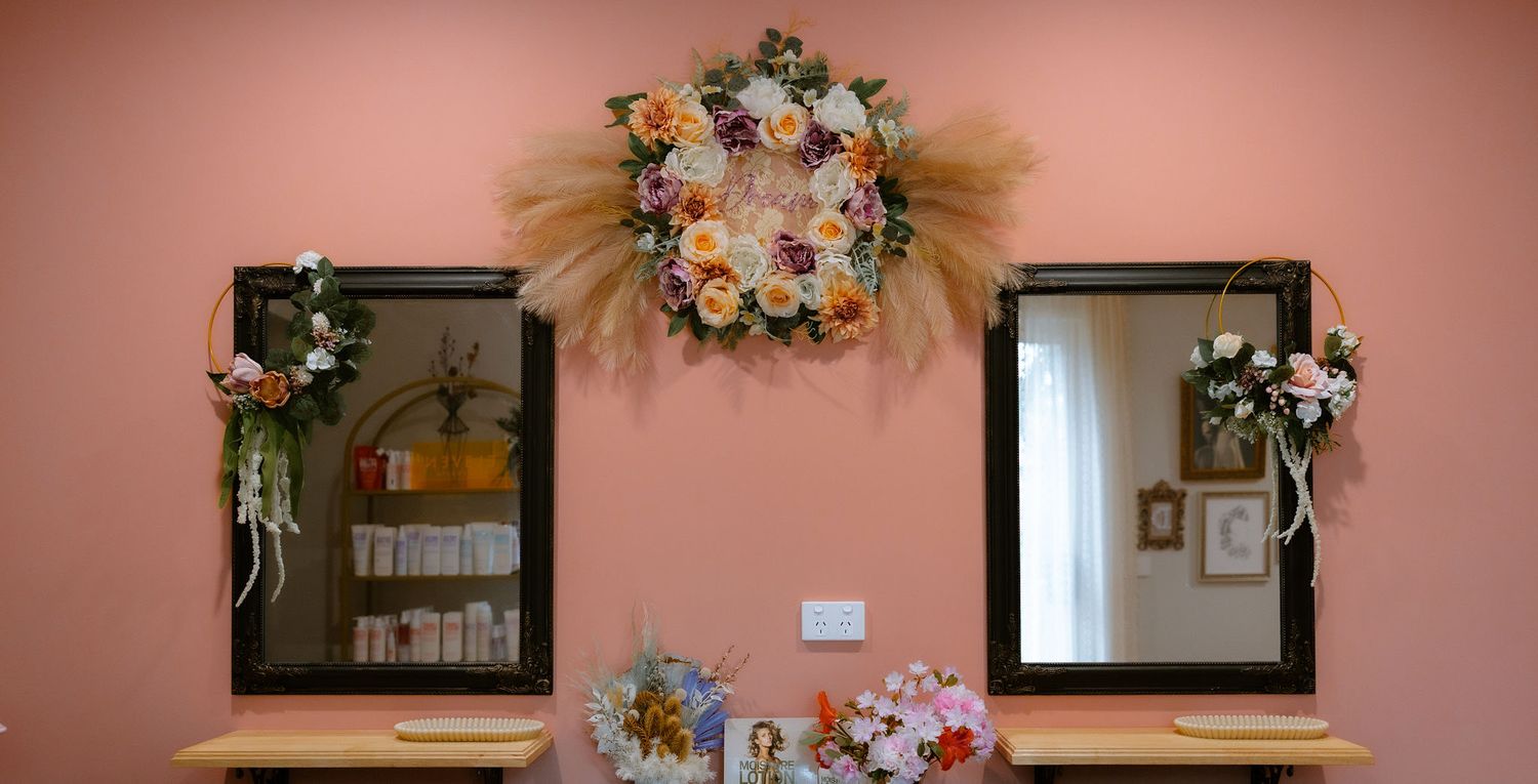 Pink walled home hair salon with floral decorations hair products in a calm warm happy space