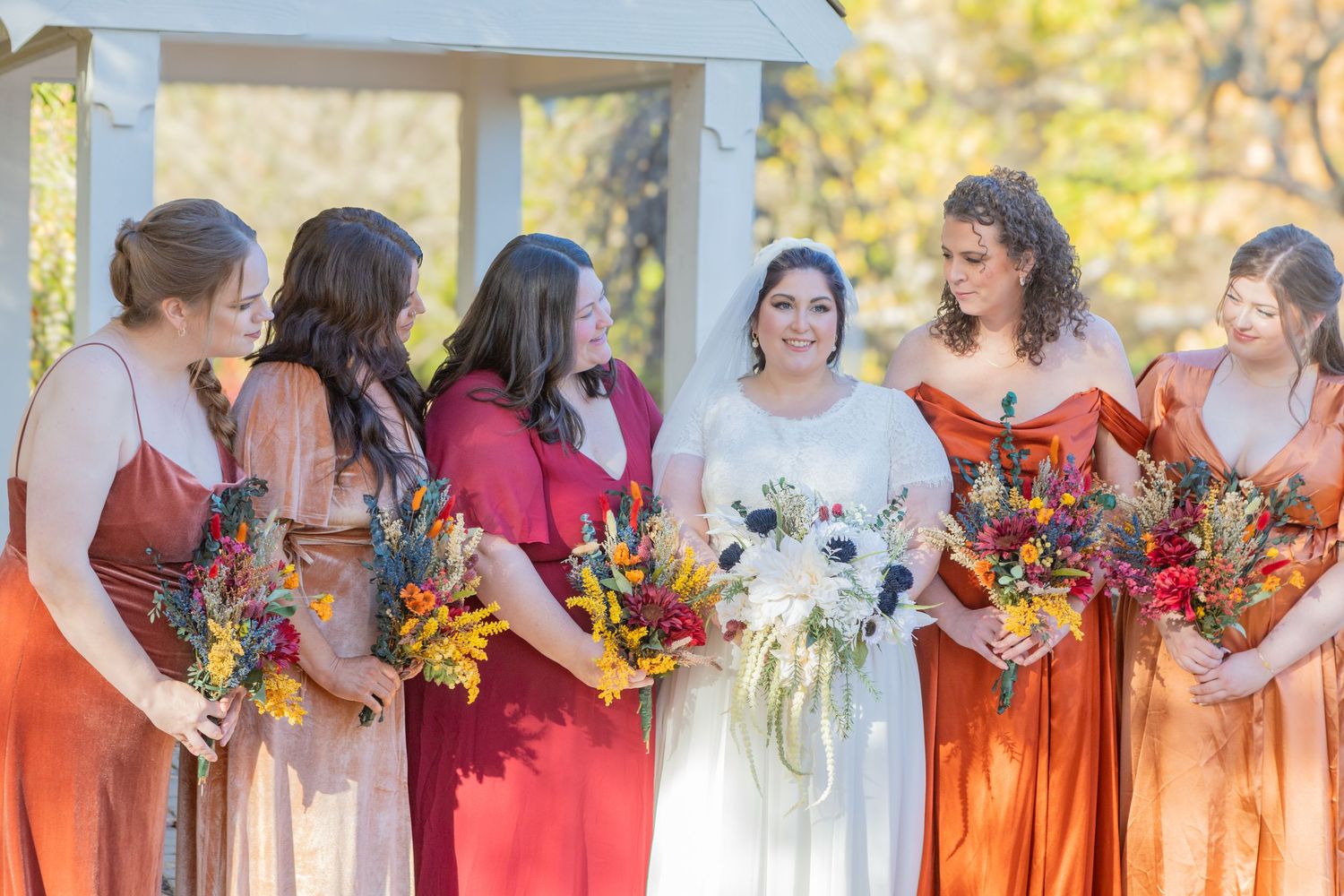 bride and her bridsmaids standing in a field in avon indiana at the avon gardens