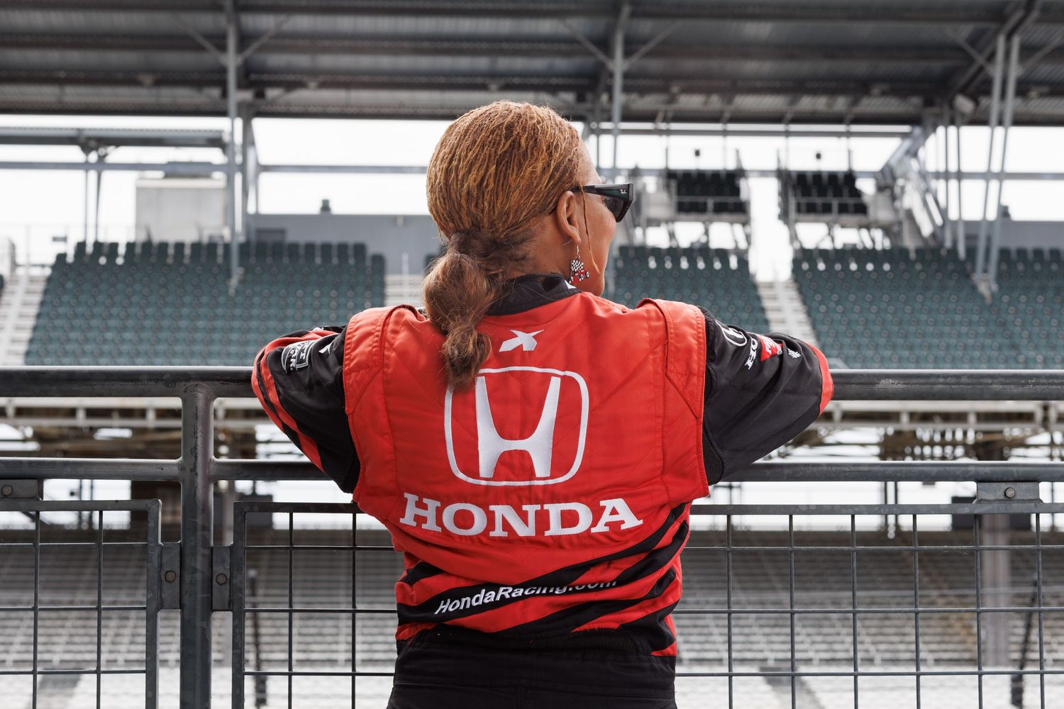 lady standing by the railing at the indy 500 motorsport in speedway indiana.