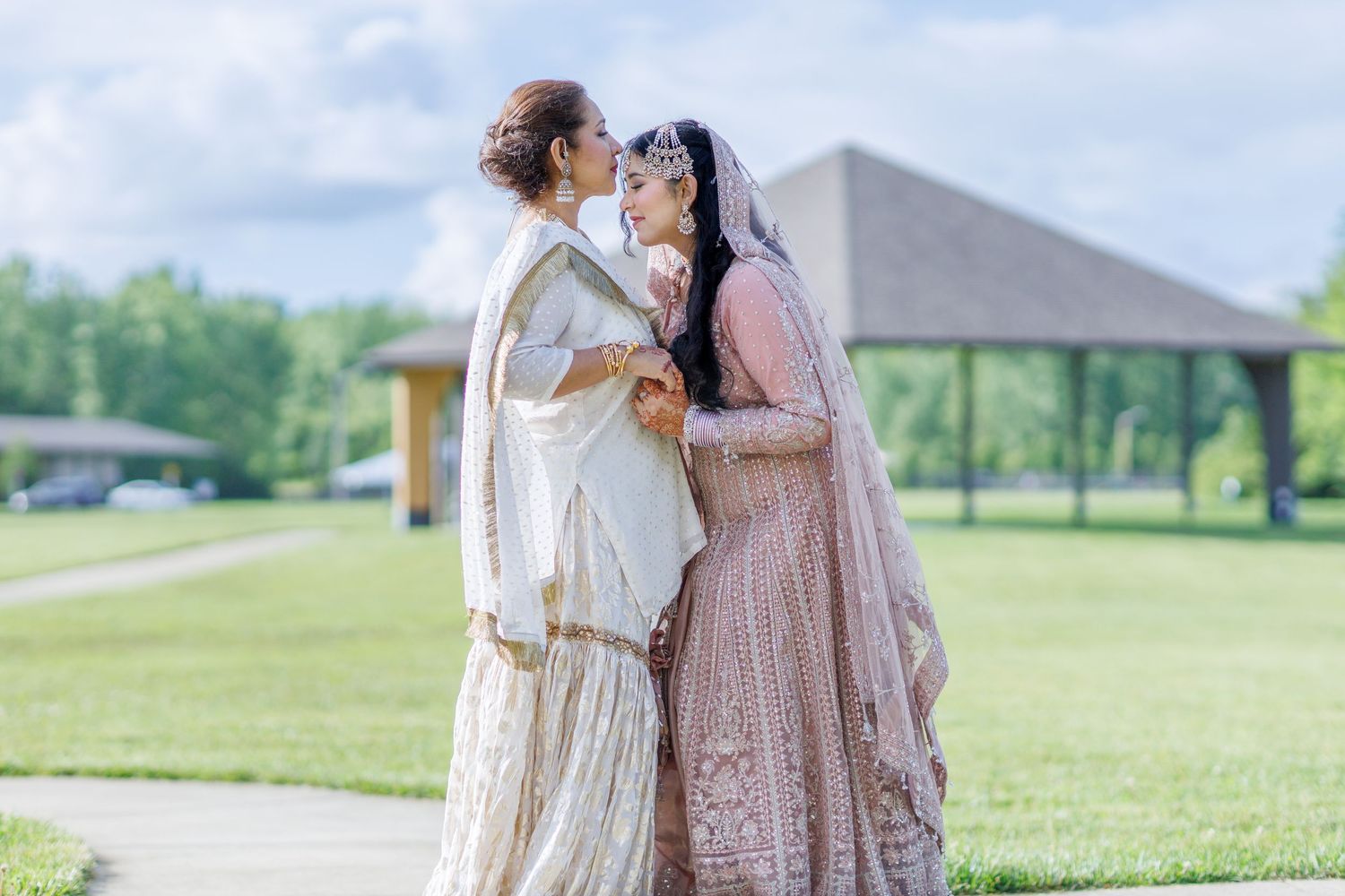 mother kissing daughters forhead before her daughter wedding ceremony in avon indiana at washington township Pavilion