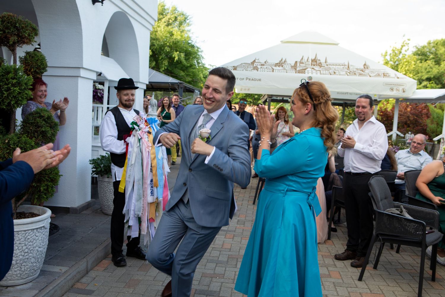 Wedding guests in formal attire dancing and celebrating at an outdoor reception.
