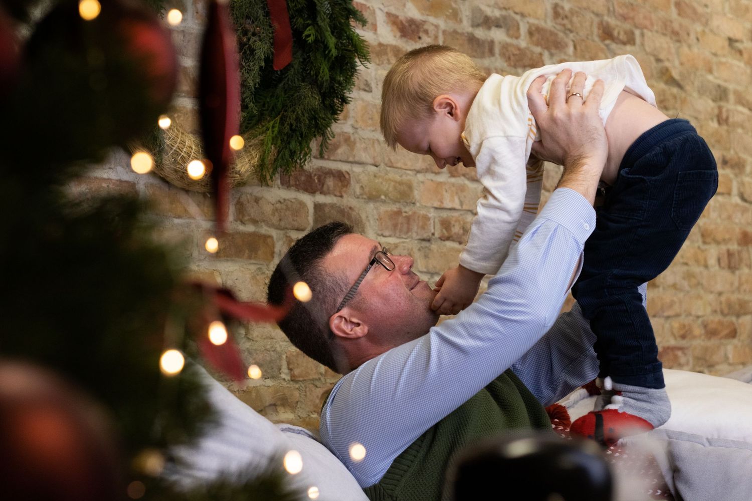 Playful family moment captured against festive holiday backdrop.