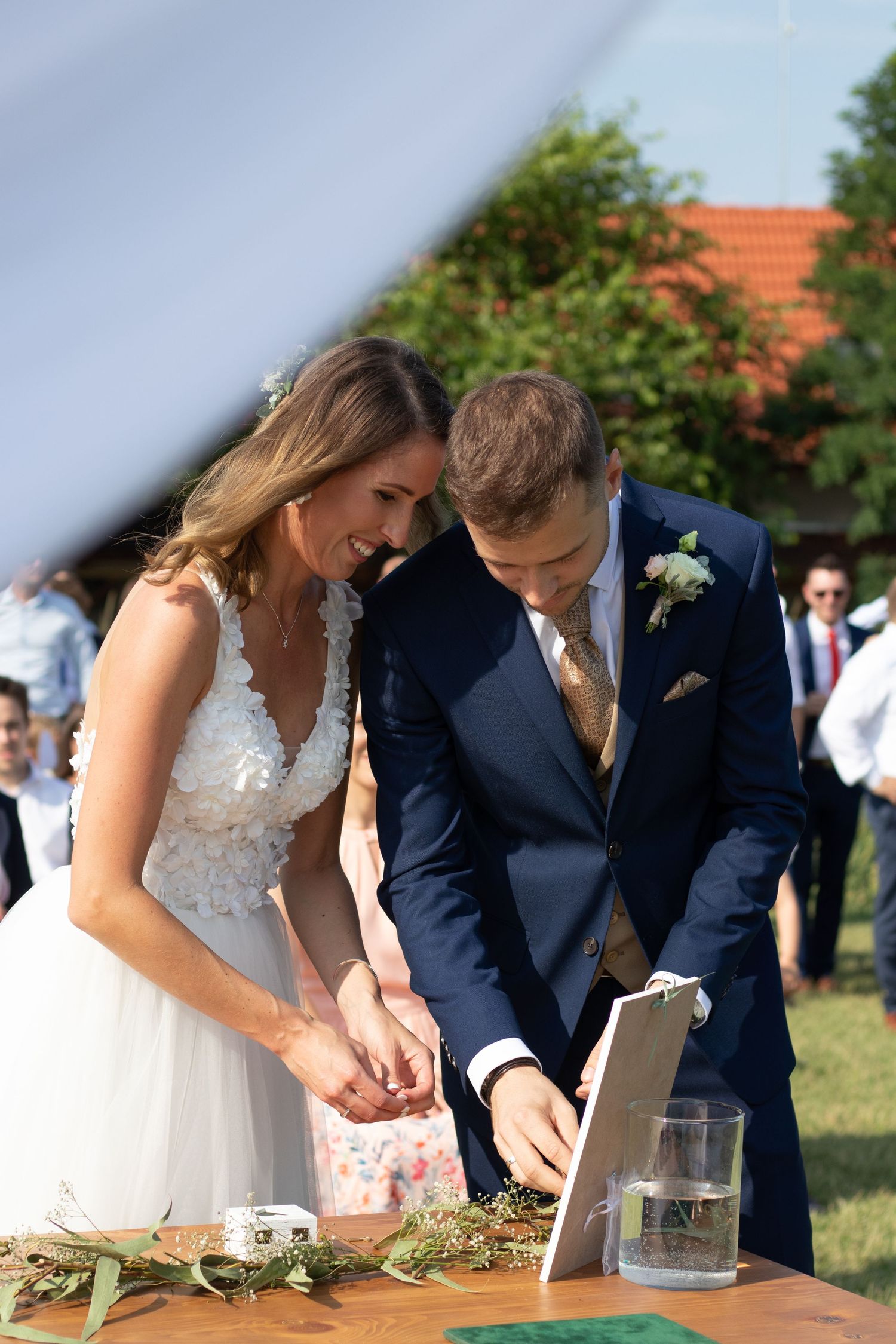 Couple performing a ceremonial ritual at an outdoor wedding reception.