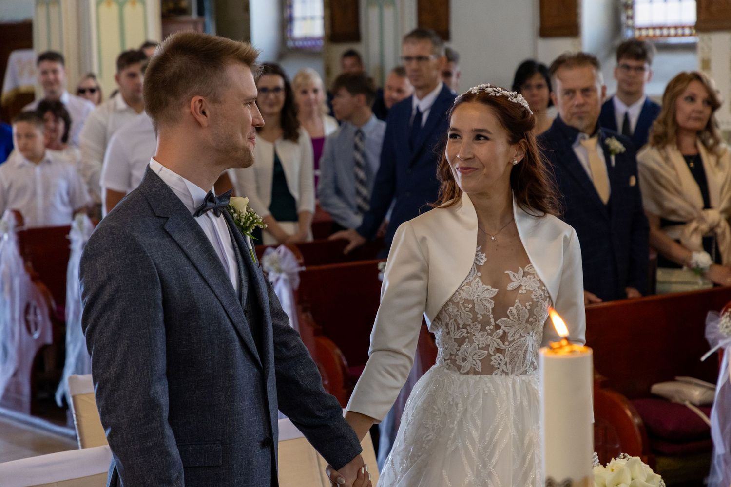 Wedding ceremony in traditional church with couple exchanging vows at altar.