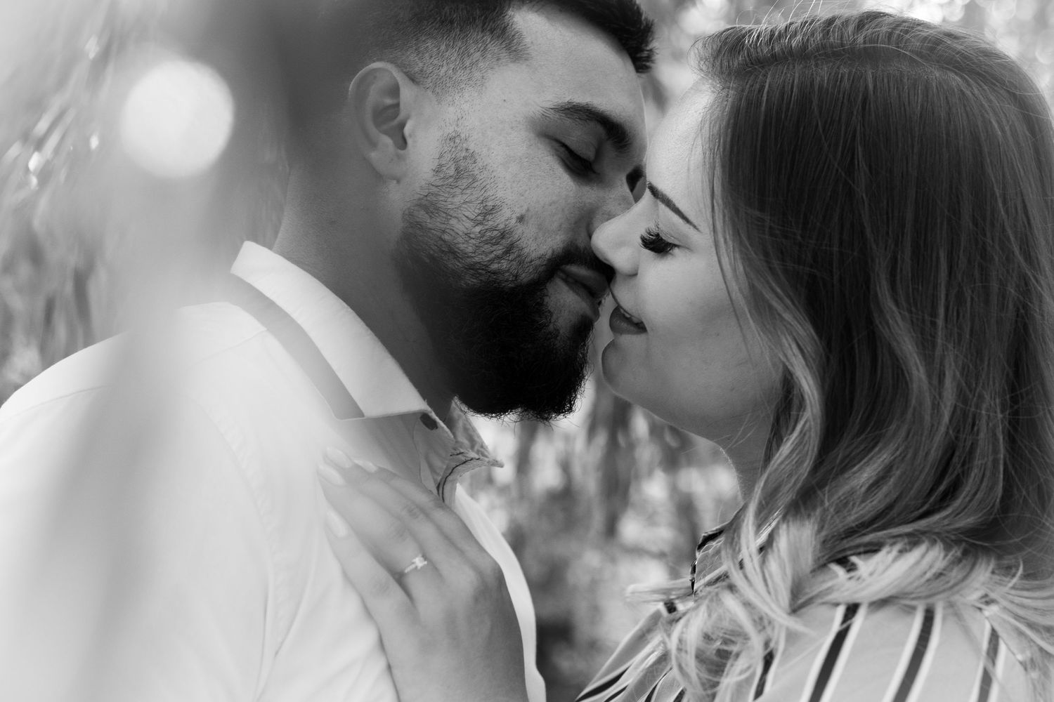Black and white close-up of a romantic couple sharing an intimate moment.