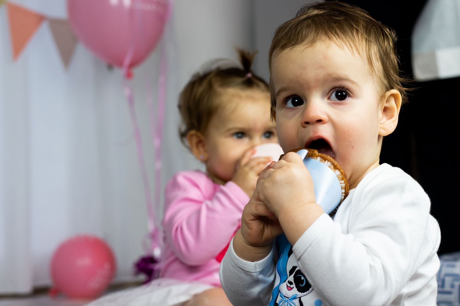 Series of cake smash photos showing baby enjoying birthday cake with pink and blue balloons in background.