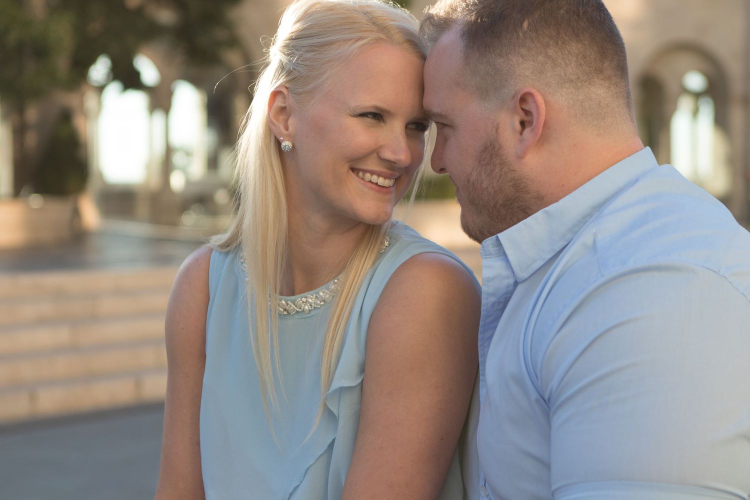 A romantic couple shares an intimate moment in soft sunlight.