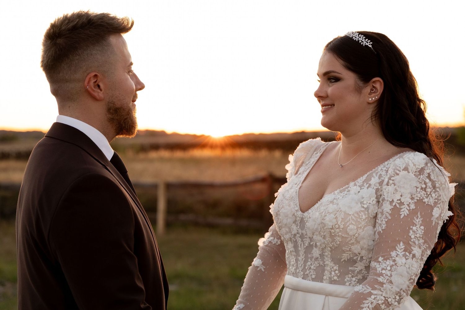 A romantic sunset moment between newlyweds in formal wedding attire.