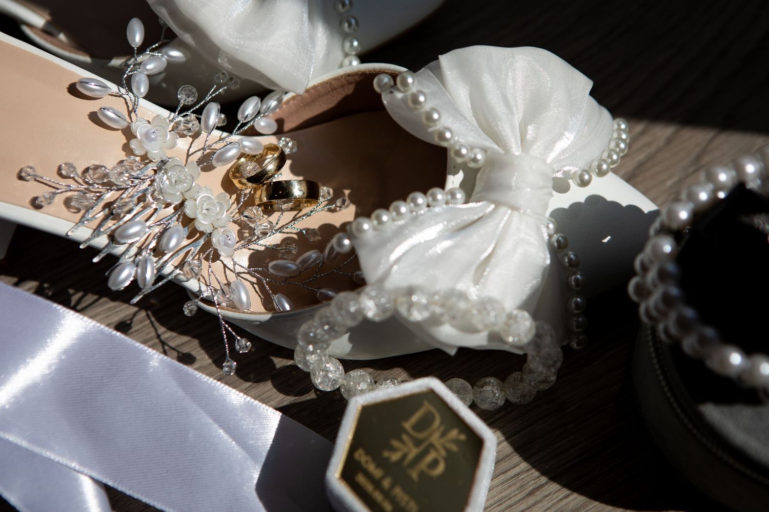 Delicate pearl and crystal wedding hair accessories on dark background.
