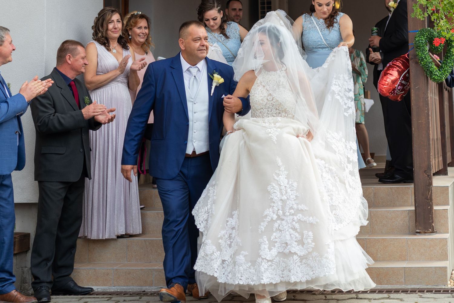 Wedding party exits church as guests celebrate with the newlyweds.