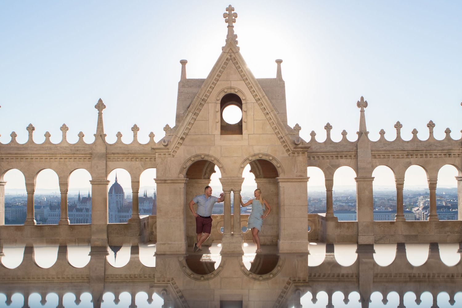 Gothic architectural details of ornate stone crosses and arches against a bright sky.