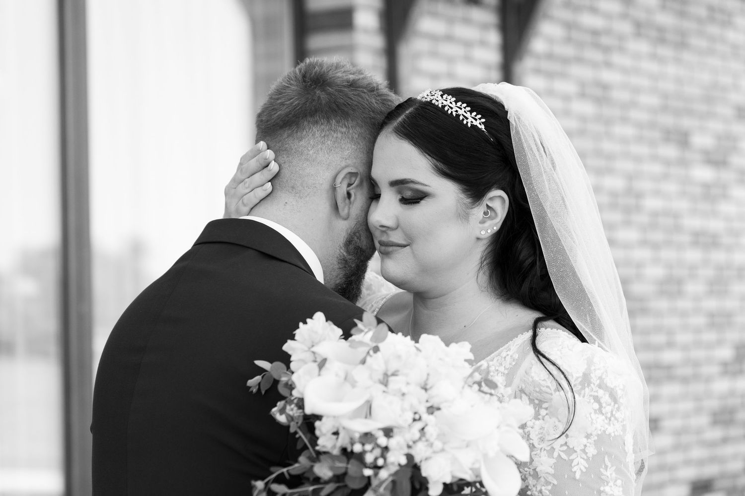 Intimate black and white wedding portrait with white floral bouquet.