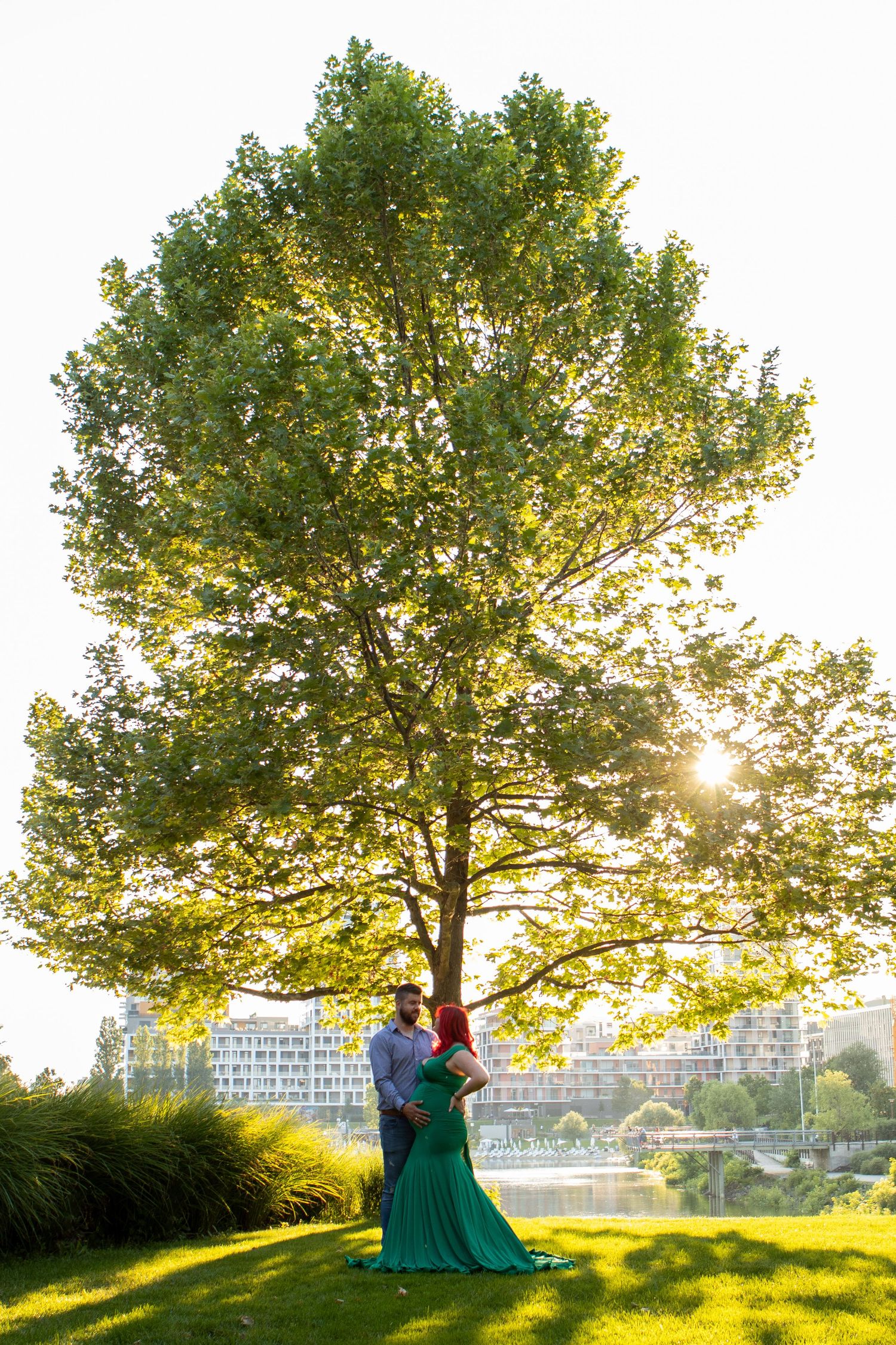 Beautiful sunset scene photo  with trees and couple silhouetted against golden light.
