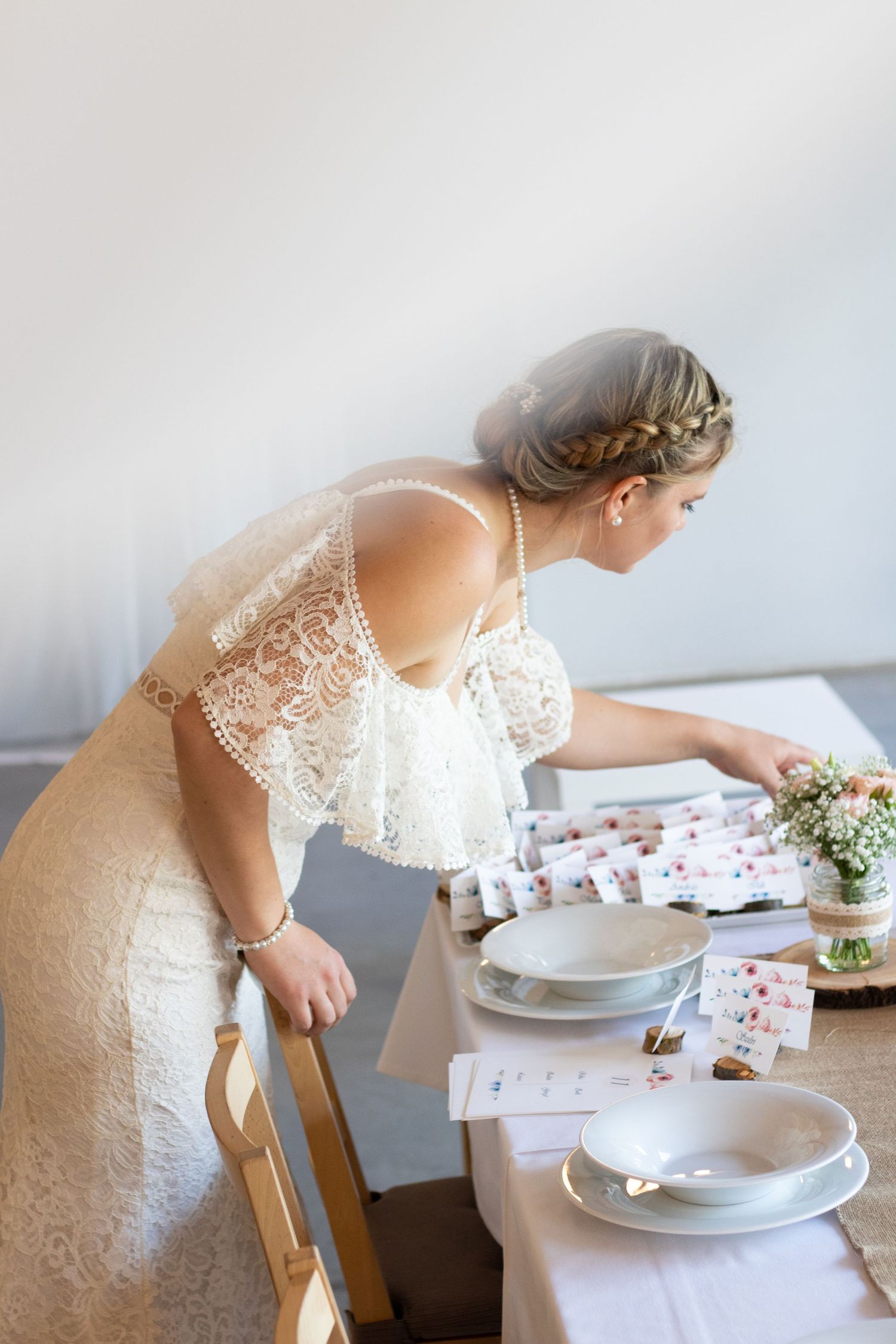 Elegant table setting with place cards and delicate floral centerpieces for a wedding reception.