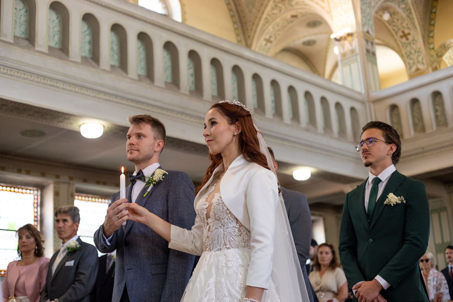 Wedding ceremony taking place in an ornate church with vaulted ceilings and elegant architecture.