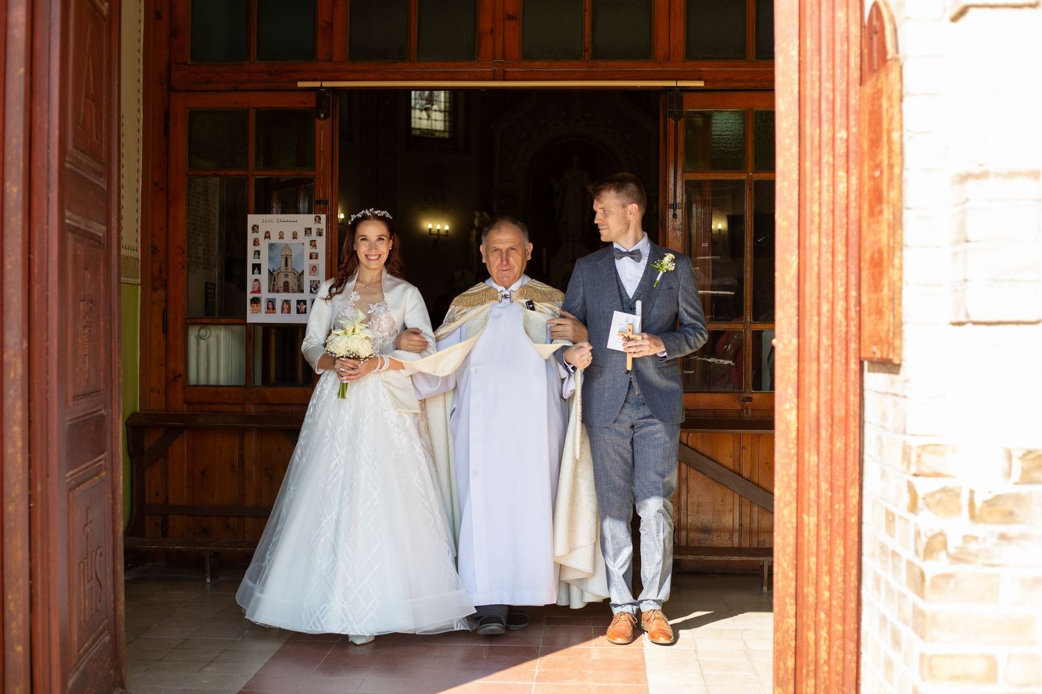 Wedding party walking through a rustic wooden doorway entrance.