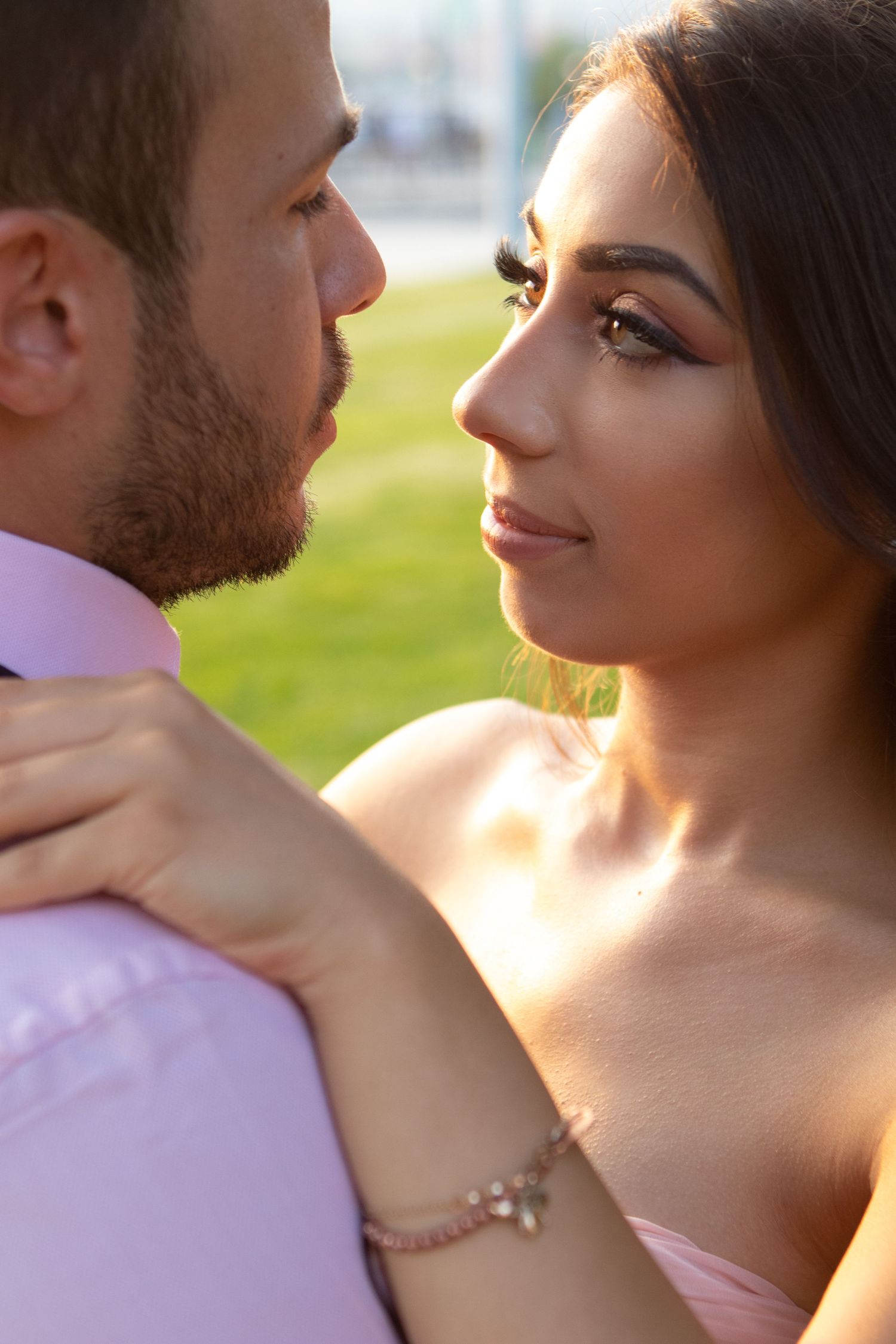 Couple in romantic embrace during golden hour with soft lighting.