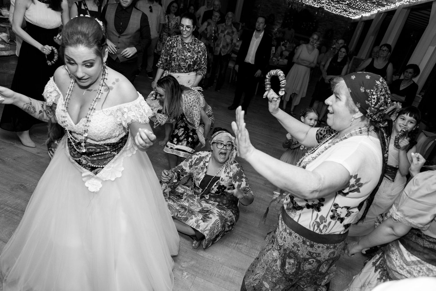 Black and white photo of wedding reception with dancing and celebration.