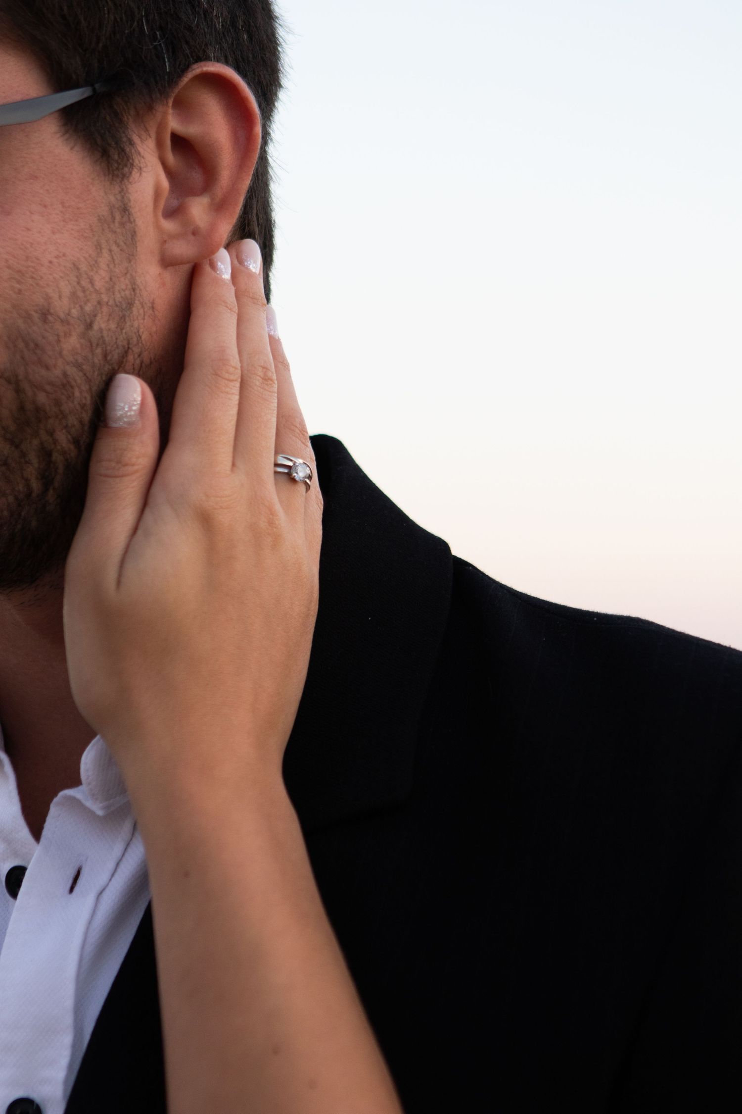 Close-up profile view of a person's hand covering their face in emotional moment.