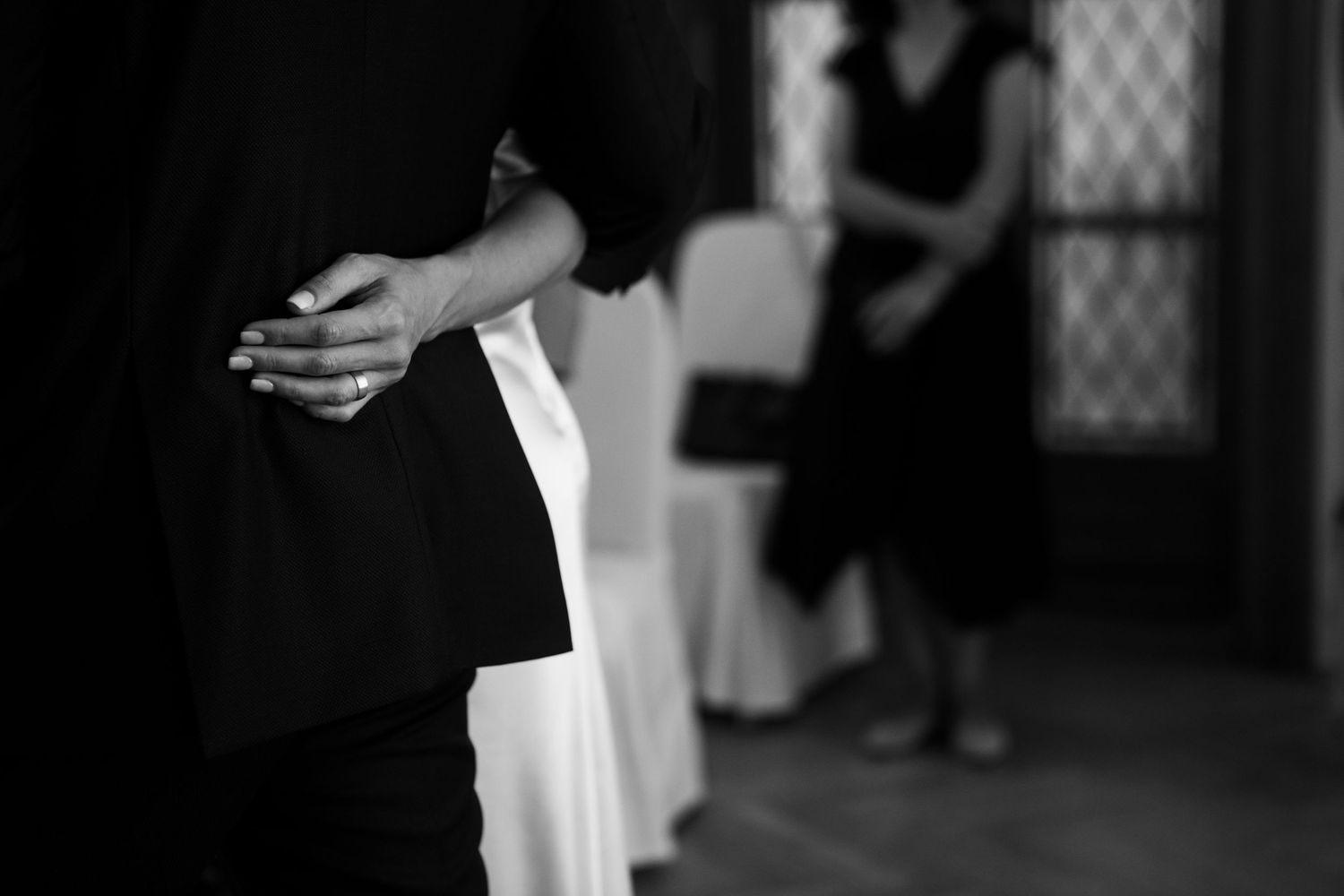 Black and white artistic photo of hands during wedding ceremony.